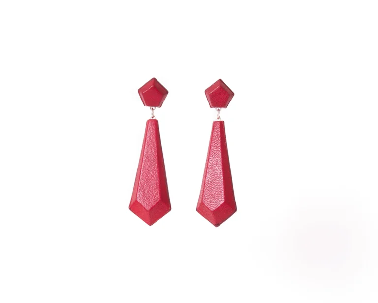 Red leather and silver earrings on white background. The earrings are drop shaped with faceted edges.